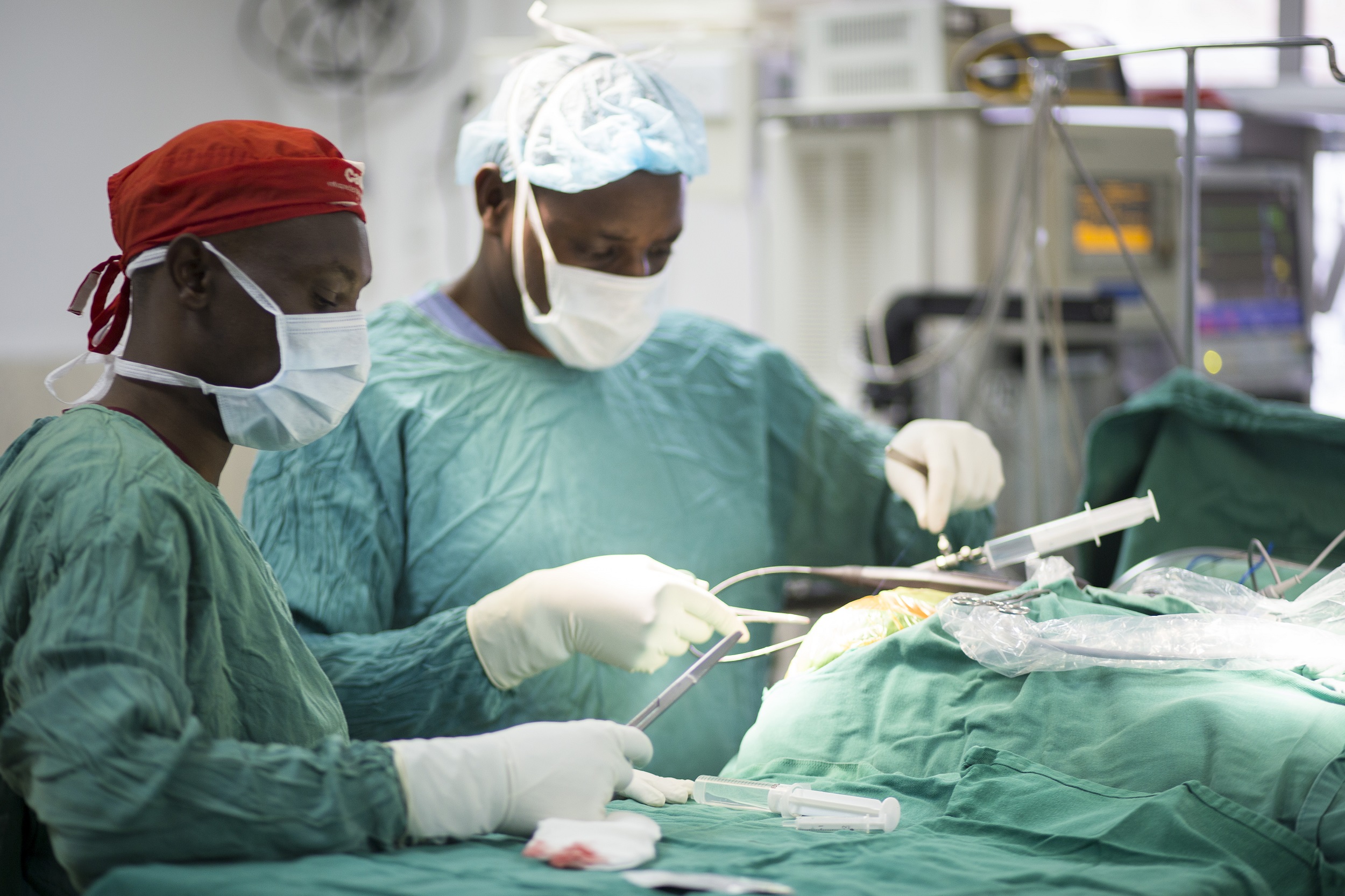two doctors operating a person in operation theatre