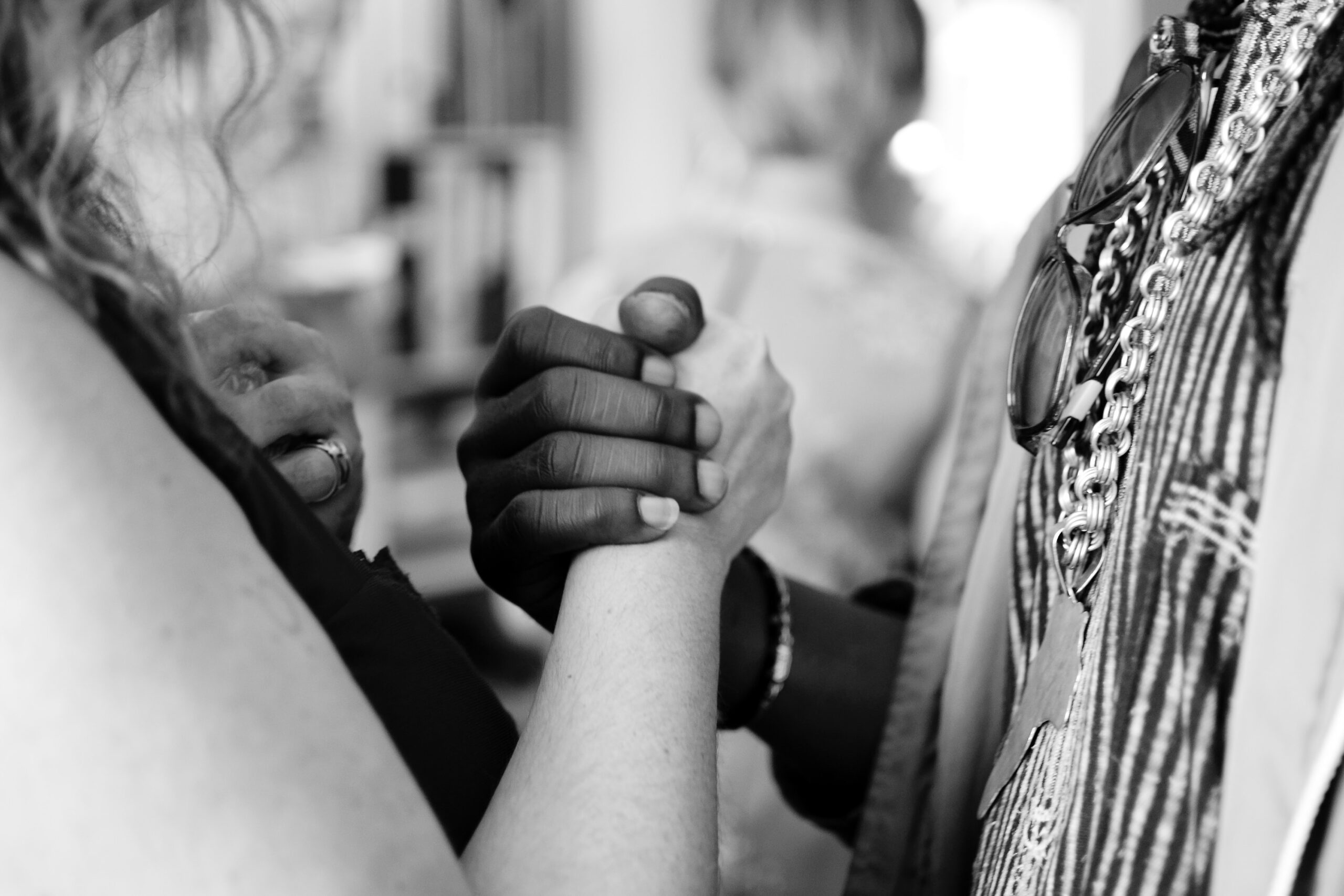 Closeup of two people firmly holding each other's hands